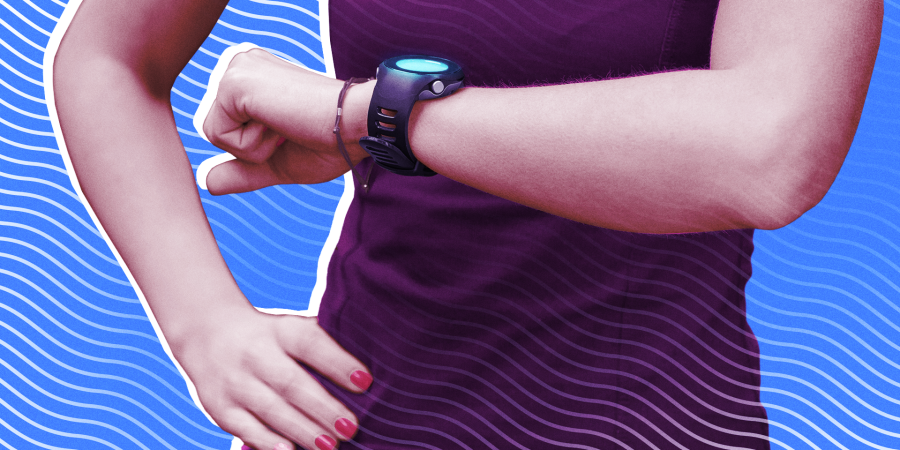 A woman in workout gear checking her fitness smartwatch